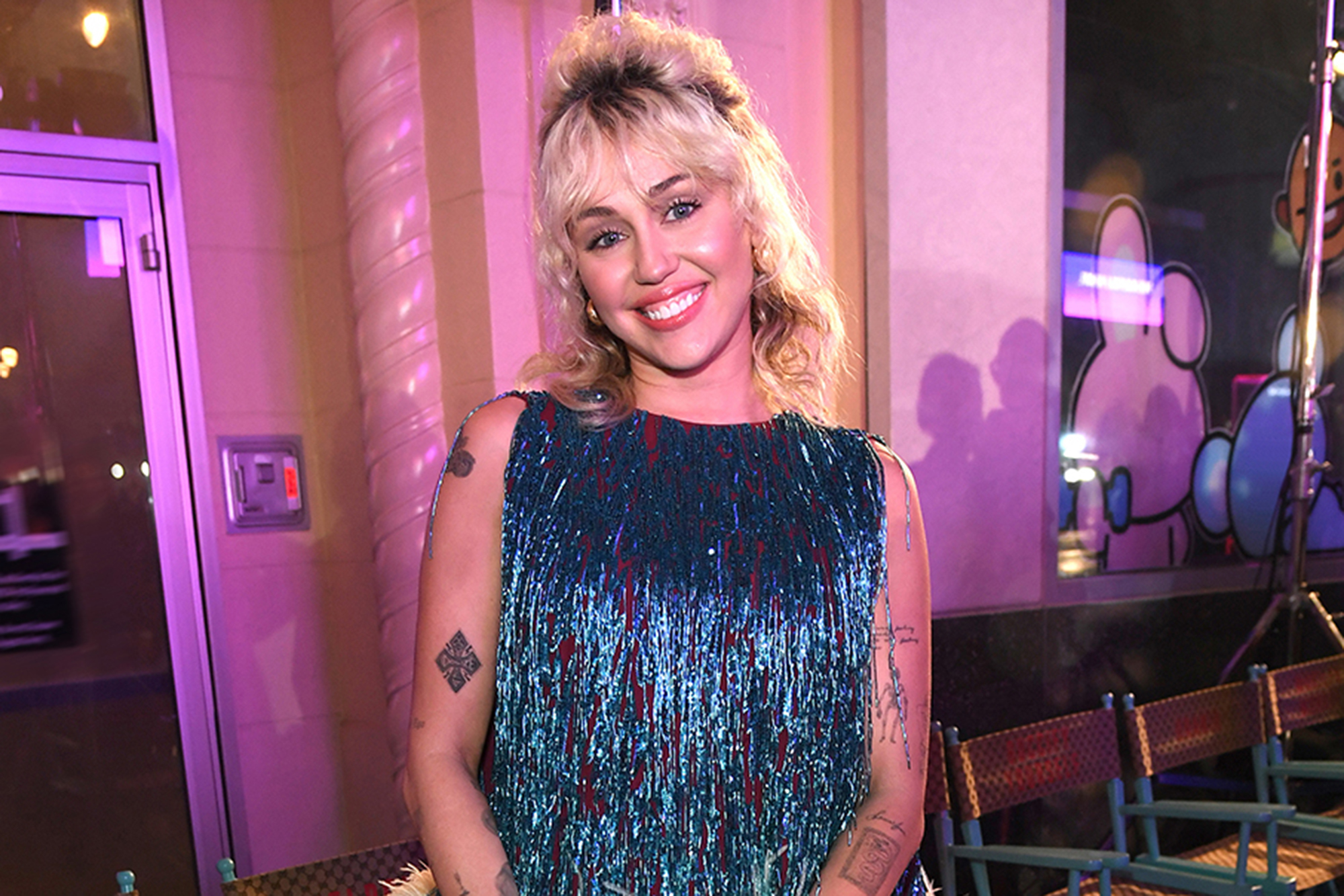 Miley Cyrus smiling in a blue sparkly dress